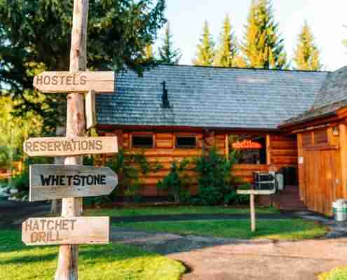 rustic wooden signs at the hatchet resort point to the hostels, reservations, whetstone, and hatchet grill